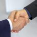 Close-up of two businessmen shaking hands, symbolizing agreement and partnership.