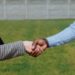 Close-up of a handshake symbolizing a real estate agreement outdoors.